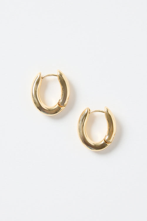 A pair of small oval-shaped wavy gold hoop earrings photographed on a clean white background.