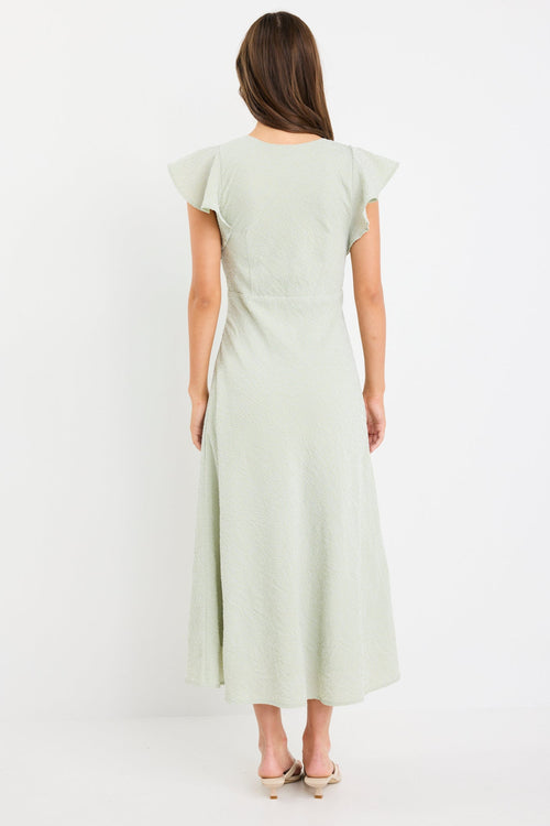 Woman wearing a sage green gingham midi dress with flutter sleeves and keyhole tie neckline.
