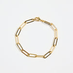gold-plated brass paperclip chain bracelet with elongated links, photographed flat on a white background.