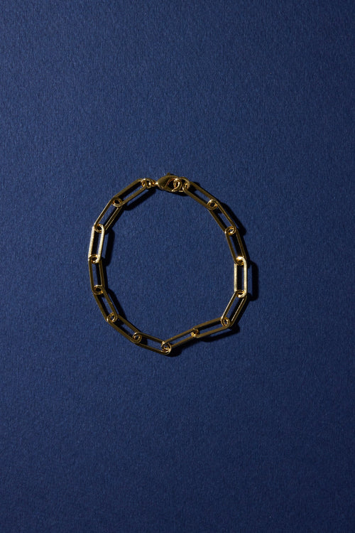 Gold chain bracelet on a dark blue background