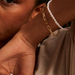 Model wears a gold chain bracelet 