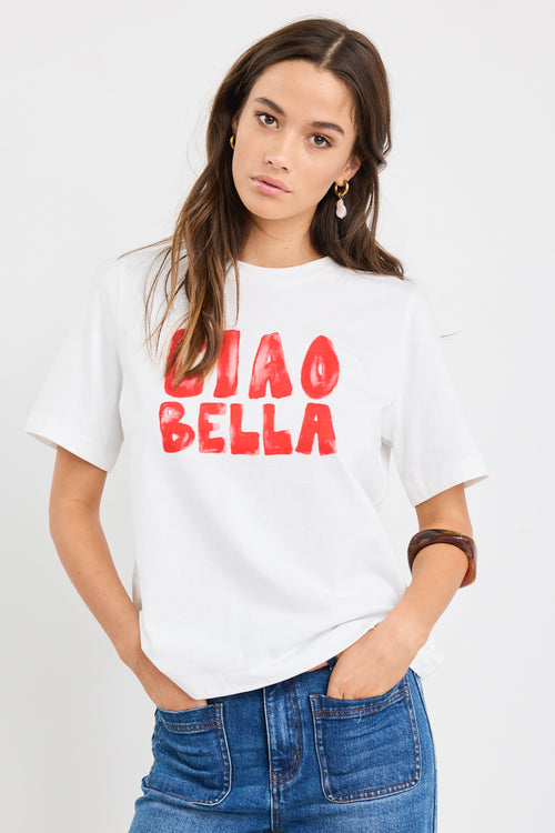 The model wears a white t-shirt with red graphic text and blue jeans