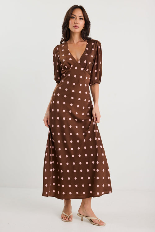 Woman wearing a brown polka dot dress on a white background