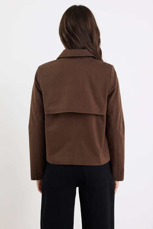 Person wearing a brown jacket on a white background