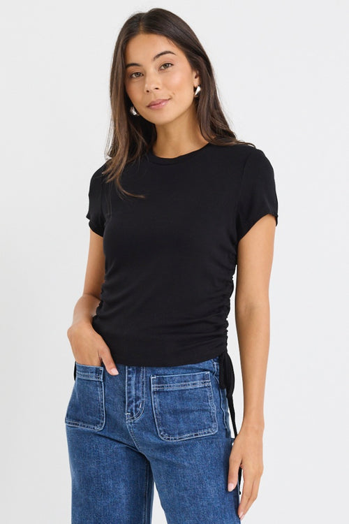 model wears a black cropped tee with blue jeans
