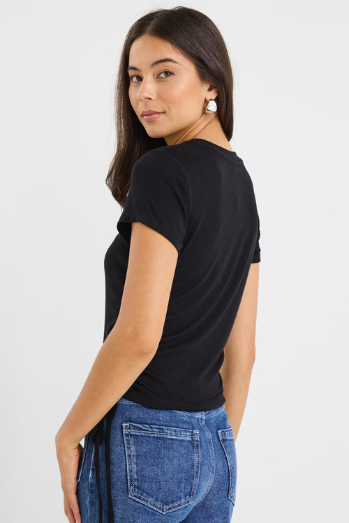 model wears a black cropped tee with blue jeans