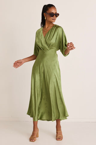 model wears a green midi dress