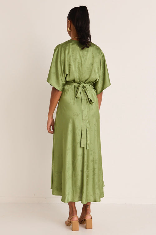 model wears a green midi dress