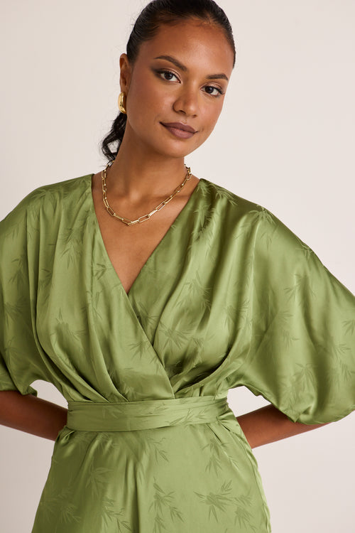 model wears a green midi dress