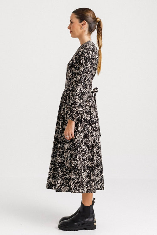 model wears a black floral midi dress