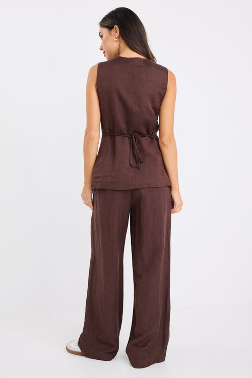 model wears a brown linen vest with brown linen pants