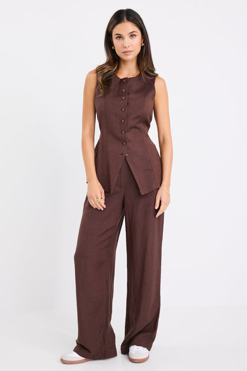 model wears a brown linen vest with dark jeans