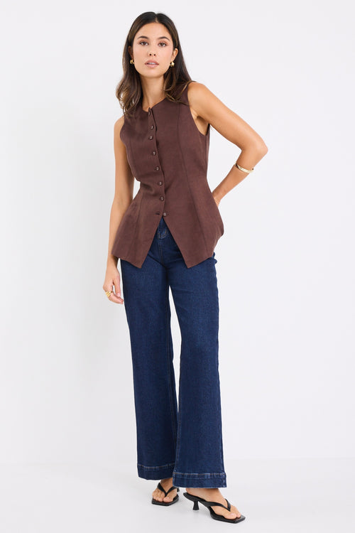 model wears a brown linen vest with dark jeans