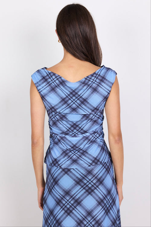 Woman wearing a blue plaid top and matching skirt against a white background