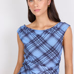 Woman wearing a blue plaid top against a white background