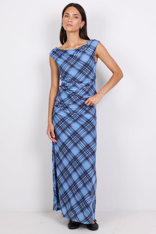 Woman wearing a blue plaid top and skirt on a white background