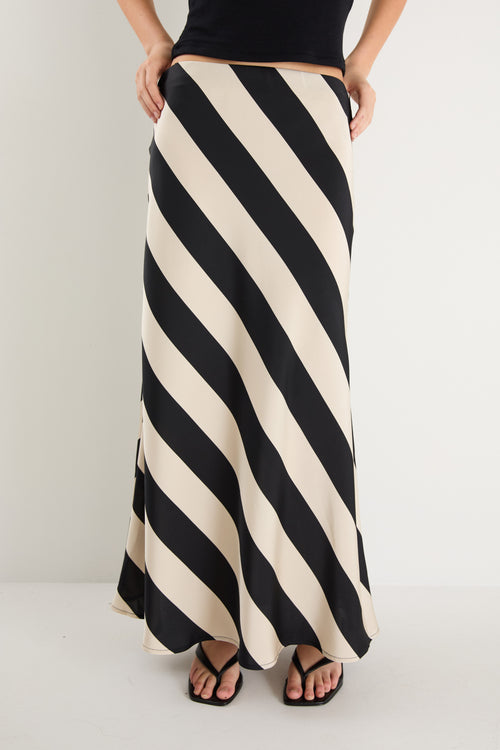 model wears a black and white stripe maxi skirt with a black tank top 
