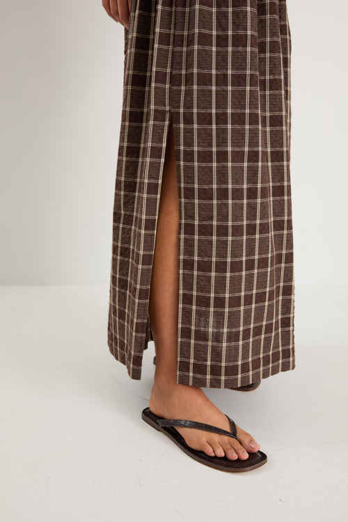 model wears a brown and beige check maxi skirt with a brown tank top
