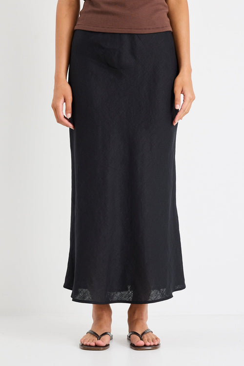 Woman wearing a black linen midi skirt and brown tank