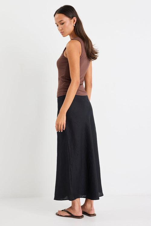 Woman wearing a black linen midi skirt and brown tank