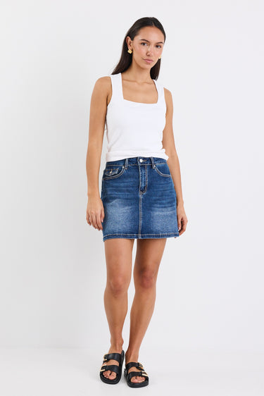 A mid-blue mini skirt with front pockets, made from a stretchy cotton blend. Features a classic denim wash, with 99% cotton and 1% elastane for a comfortable, breathable fit.