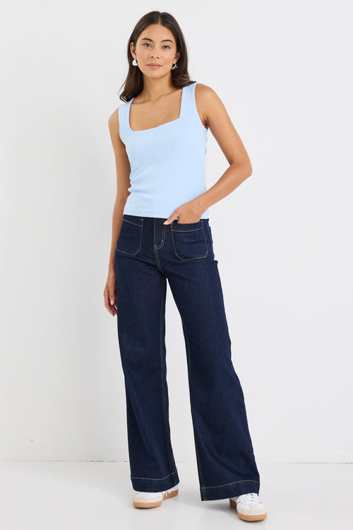 woman wearing a pale blue square-neck sleeveless tank paired with indigo jeans