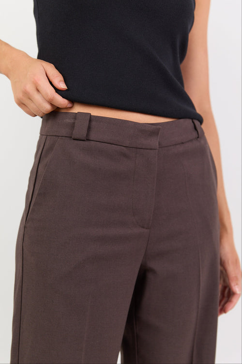 Brown pants worn by a person on a white background