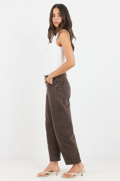 Woman wearing a white tank top and brown pants on a white background