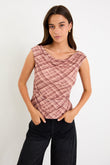 Model wearing a sleeveless blush check mesh top with a scoop neckline and ruched bodice