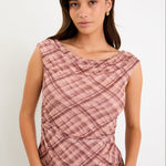 Model wearing a sleeveless blush check mesh top with a scoop neckline and ruched bodice