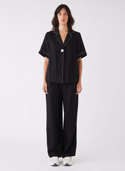 model wearing a black top with contrast stitching