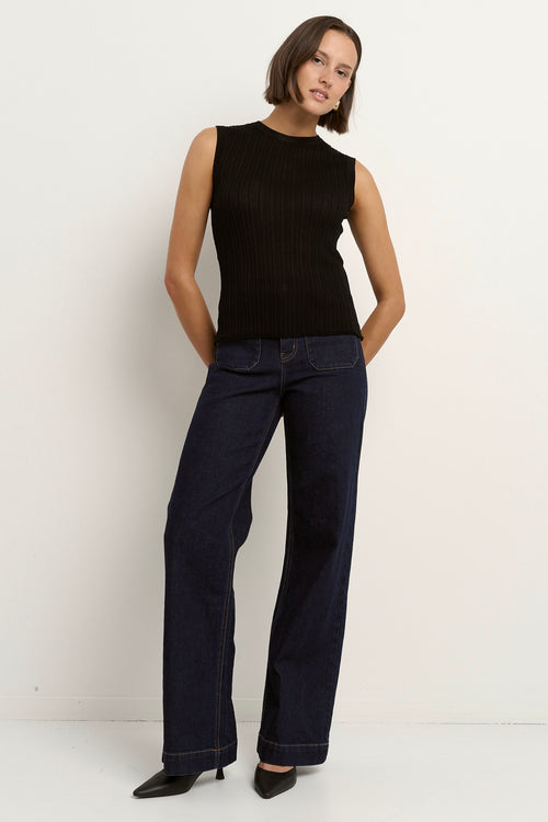 model wears a black high neck tank top with dark blue jeans