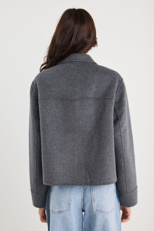 Person wearing a grey jacket and light blue jeans on a white background
col_pattern