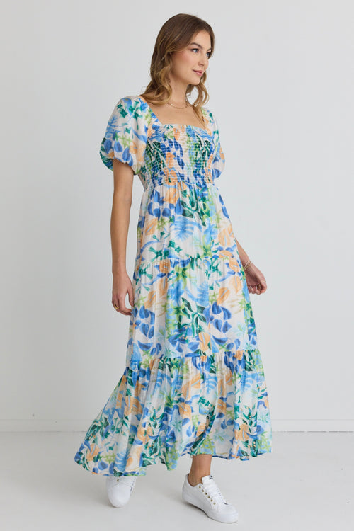 model and wears and blue and orange floral maxi dress with sandals