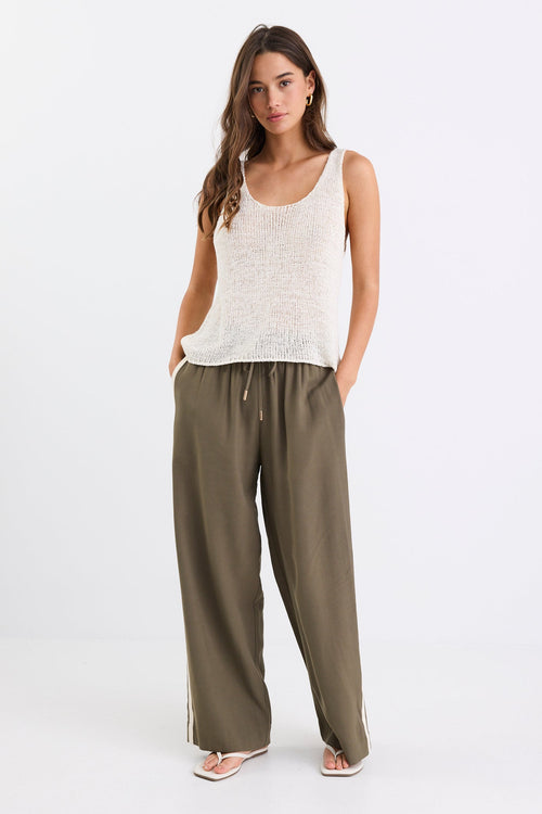 Woman wears a white natural knit top and khaki pants