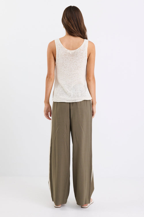 Woman wears a white natural knit top and khaki pants
