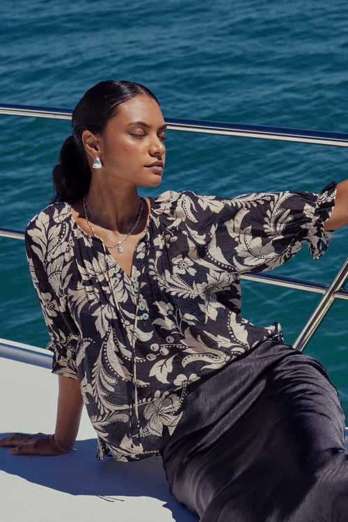 model wears a black floral top