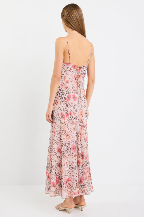 Woman wearing a strappy maxi dress in soft georgette with a floral and animal print blend, bias cut design, and flowing silhouette.