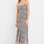 Woman wearing a leopard print strappy maxi dress in lightweight georgette with a bias cut and flowing silhouette.