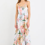 Woman wearing a Tuscan sunset-inspired strappy tiered midi dress with a vibrant print and flowing silhouette.