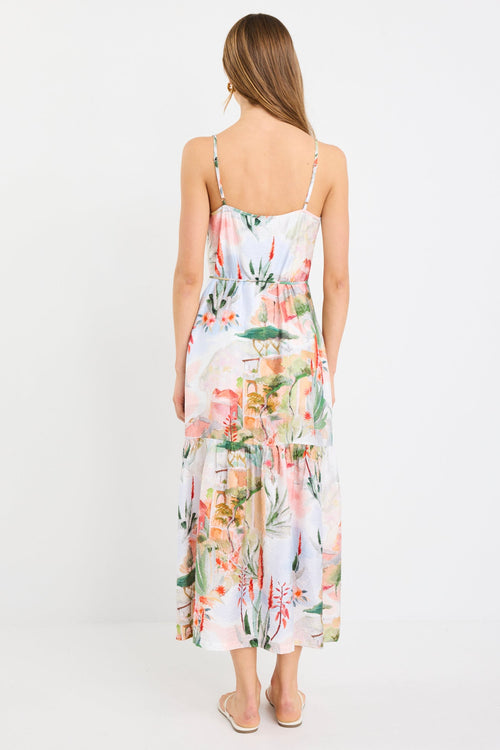 Woman wearing a Tuscan sunset-inspired strappy tiered midi dress with a vibrant print and flowing silhouette.