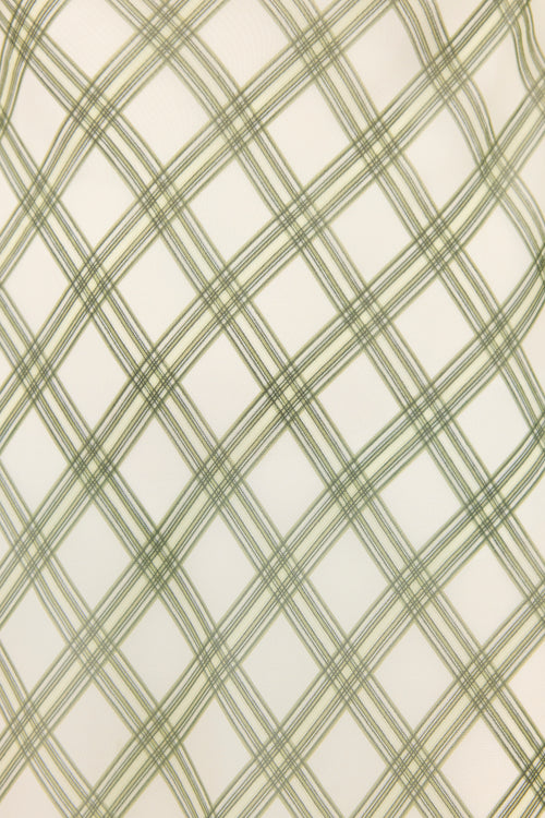 A close-up of a fabric or wallpaper pattern featuring a green diagonal plaid design over an off-white background.