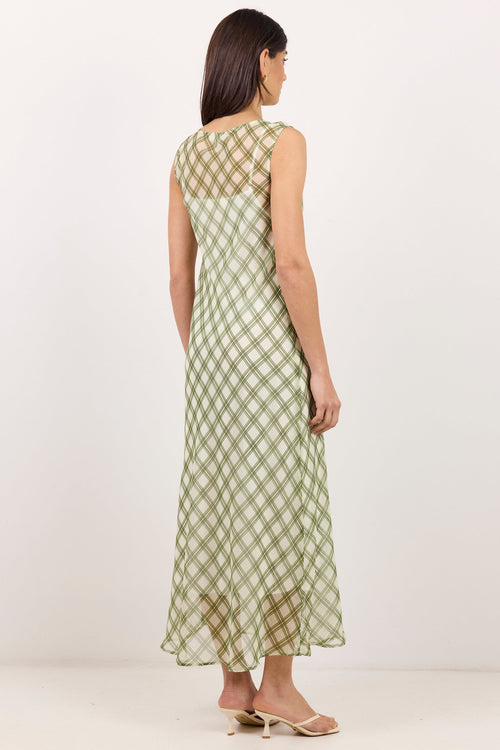 A woman modeling a sleeveless midi dress with a green and beige gingham pattern, shown from the back against a plain white studio background.