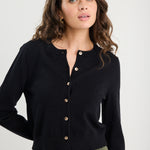 Woman wearing a black cardigan with a plain background