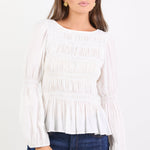 Woman wearing a white blouse and blue jeans on a white background