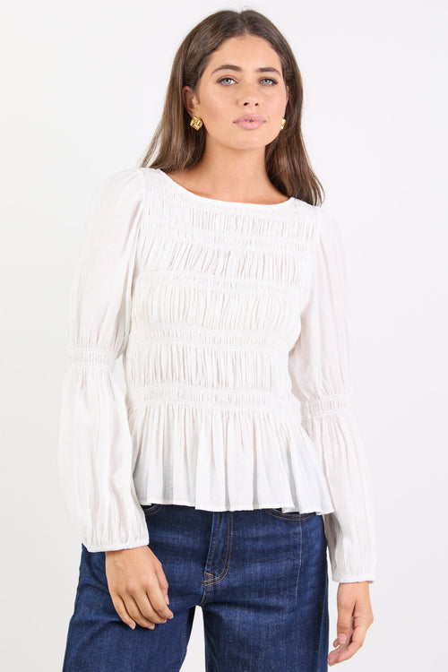 Woman wearing a white blouse and blue jeans on a white background