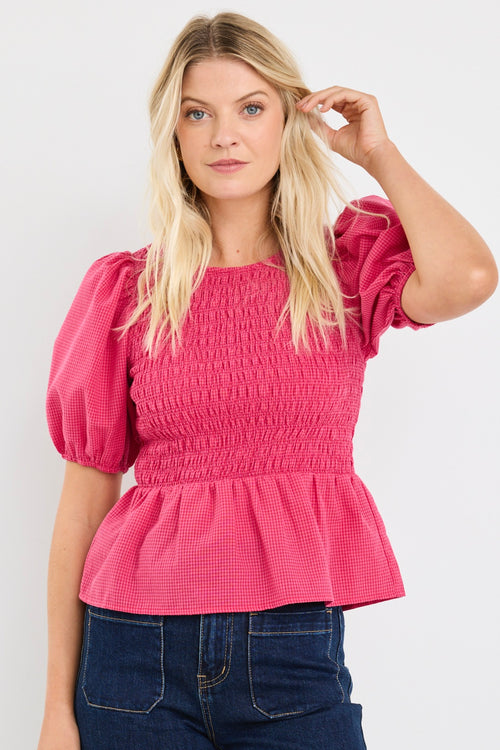 model wears a pink gingham puff sleeve top with dark blue jeans
col_pattern