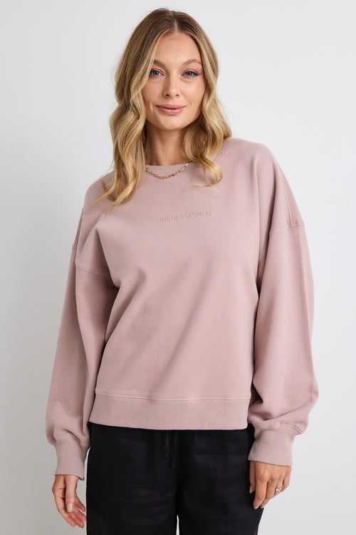 model wears a pink sweatshirt