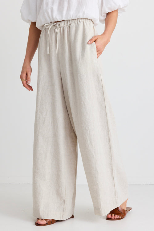 model wears a beige wide leg linen pant