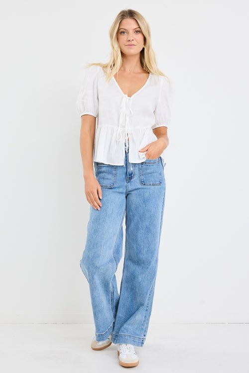 model wears a white linen puff sleeve top and light blue